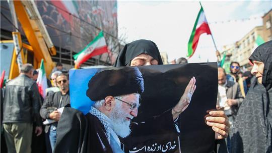 Eine Trauernde hält beim Begräbnis des von Israel getöteten Generalsekretärs des iranischen Sicherheitsrats, Ali Laridschani, ein Bild des ebenfalls getöteten Obersten Führers Ajatollah Ali Chamenei in die Höhe. 