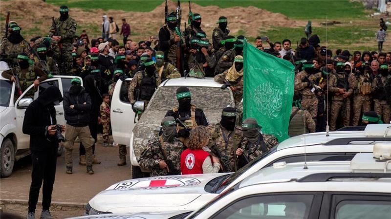 Eine Vertreterin des Roten Kreuzes spricht mit Hamas-Mitgliedern. 