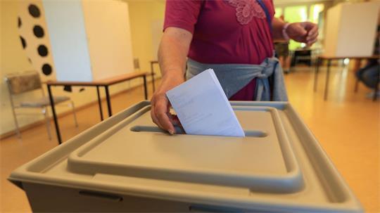 Eine Wählerin wirft in einem Wahllokal in Wernigerode ihren Stimmzettel in eine Wahlurne.