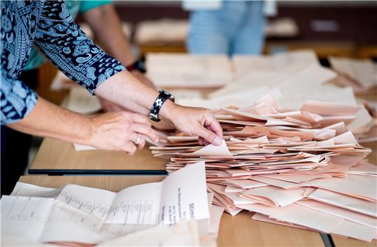 Eine Wahlhelferin sortiert in einem Wahllokal die Stimmzettel für die Auszählung. Foto: Hauke-Christian Dittrich/dpa