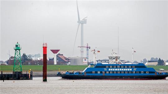 Eine Weserfähre ist bei trübem Wetter auf der Weser unterwegs. 