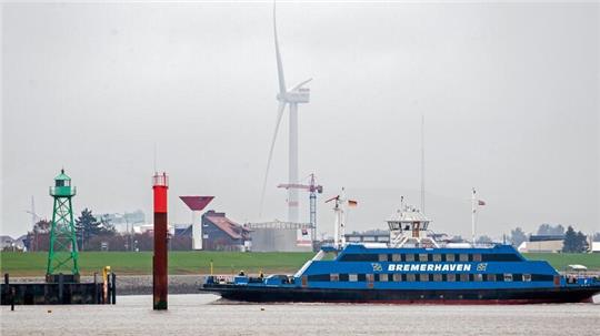 Eine Weserfähre ist bei trübem Wetter auf der Weser unterwegs.