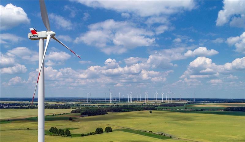 Eine Windenergieanlage des Herstellers Vestas dreht sich vor wolkigem Himmel.