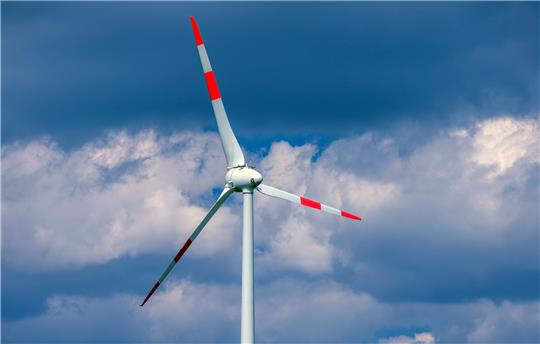 Eine Windkraftanlage dreht sich in einem Windpark. Foto: Jens Büttner/dpa