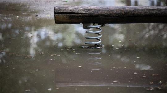 Eine Wippe auf einem Spielplatz steht im Wasser.