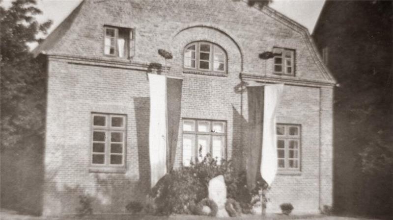 Eine alte Aufnahme der Alten Turnhalle - von wann ist unbekannt. Banner hängen beidseitig der Gedenkstätte für gefallene Soldaten, die sich noch heute auf der Rückseite des Gebäudes befindet.