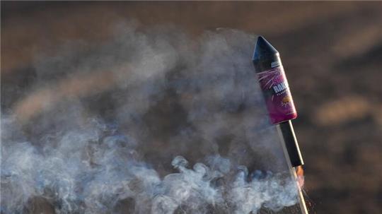 Eine angezündete Silvester-Rakete steckt im Boden.