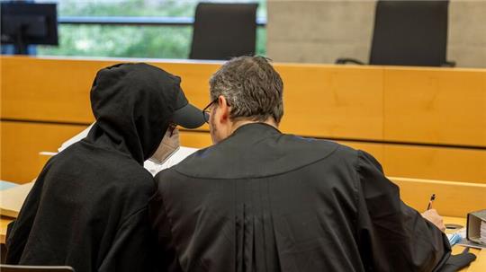 Eine der beiden Angeklagten (l) unterhält sich mit ihrem Rechtsanwalt im Sitzungssaal im Landgericht.