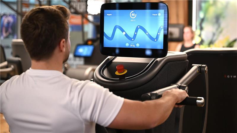 Eine digitalisierte Ruderbank in einem Fitnessstudio, auf deren Display der Nutzer mit seiner Kraftanstrengung eine Figur eines Computerspiel steuert: Solche Daten könnten für eine Trainingsanalyse ausgewertet werden.