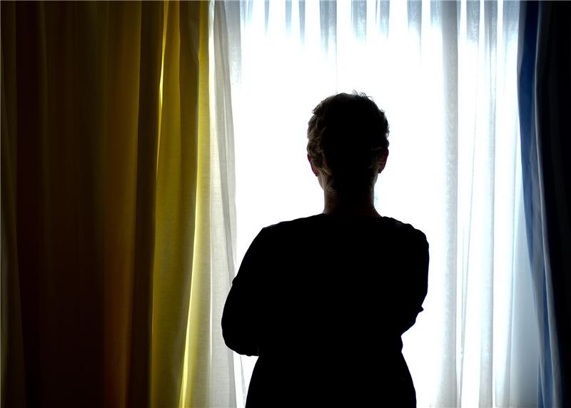 Eine junge Frau steht in einem Zimmer eines Frauenhauses. Foto: Peter Steffen/dpa