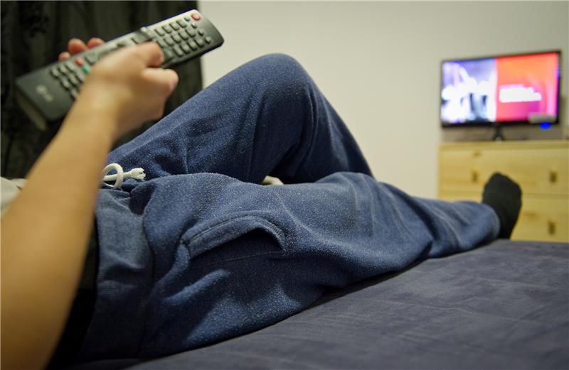 Eine junge Frau trägt vor dem Fernseher eine Jogginghose. Die Pandemie stellt Paarbeziehungen auf die Probe. Knirschte es schon vorher, kann es nun richtig schwierig werden. Eine Psychologin sieht den bevorstehenden Valentinstag als Chance. Foto: Christoph Schmidt/dpa