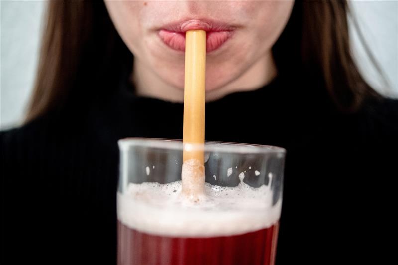 Eine junge Frau trinkt durch einen Trinkhalm aus Bambus aus einem Glas. Foto: Hauke-Christian Dittrich/dpa