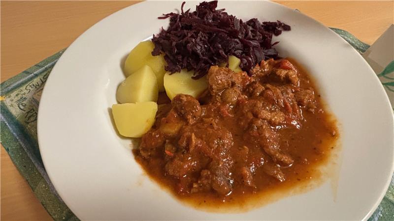 Eine leckere warme Mahlzeit für Gäste: Kartoffeln, Rotkohl und veganes Gulasch aus Soja.