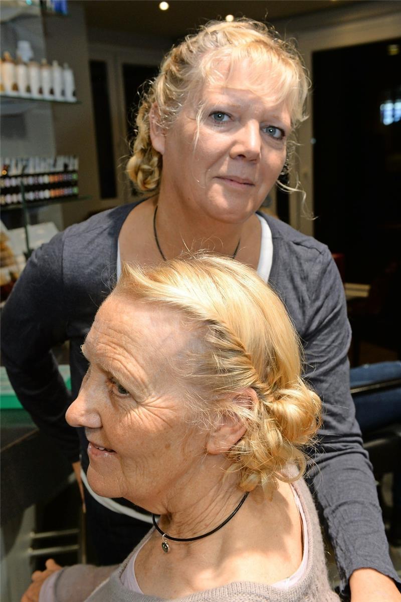 Eine neckische Flechtfrisur gestaltet hier Gitta Ahrend in den Haaren ihrer Mutter Ilse Schomaker.