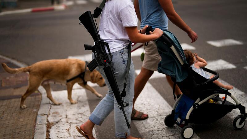 Netanjahu: Zweite Phase des Gaza-Krieges hat begonnen Eine nicht im Dienst befindliche israelische Soldatin, trägt während eines Spaziergangs durch Tel Aviv ihre Waffe.