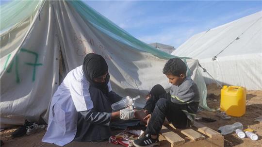Eine palästinensische Ärztin behandelt einen Jungen vor ihrer Zeltklinik in Rafah.