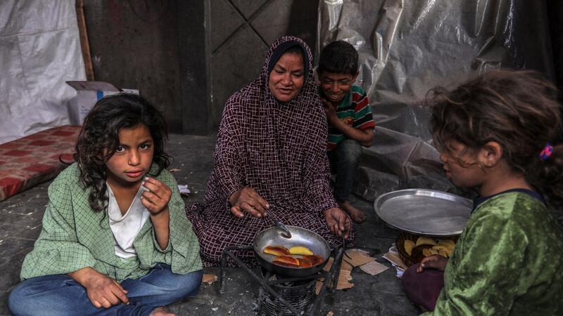 Eine palästinensische Familie kocht in einem behelfsmäßigen Zelt in Rafah.