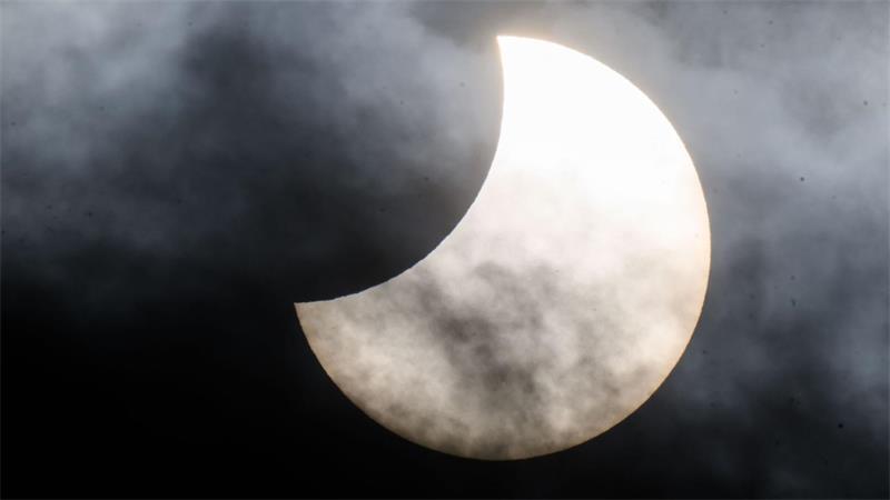 Gutes Wetter bei Sonnenfinsternis und Sternschnuppen Eine partielle Sonnenfinsternis ist zwischen Wolken am Himmel zu sehen. (Archivbild)