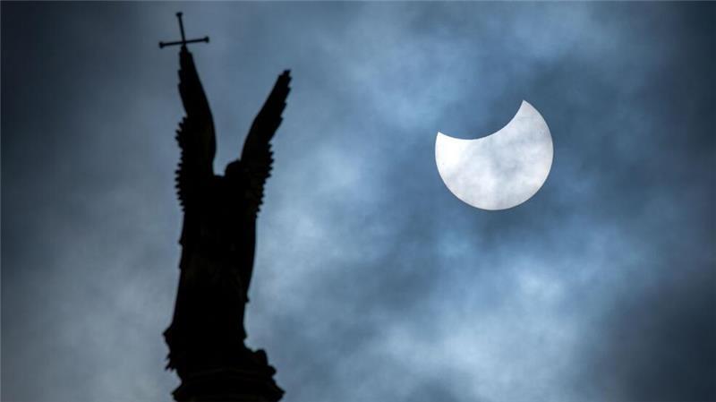 Mond- und Sonnenfinsternis im März: Wo man sie im Norden sehen kann Eine partielle Sonnenfinsternis über der Statue des Erzengel Michael auf der Kuppel des Schweriner Schlosses.