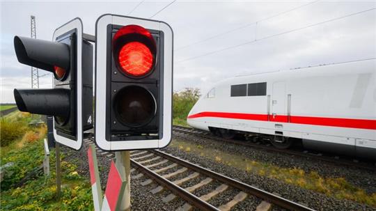 Eine rote Ampel leuchtet an einem Bahnübergang. Der Bahnverkehr auf der ICE-Strecke zwischen Köln und Frankfurt ist für eine Woche eingestellt.