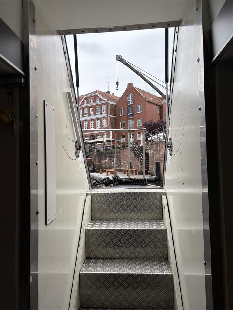 Eine schmale Treppe führt nach draußen. Die Tür öffnet sich nach oben.