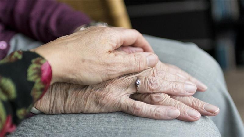 Suche nach dementer 74-Jährigen nimmt glückliches Ende Eine Hand einer Frau liegt auf der Hand einer Seniorin.