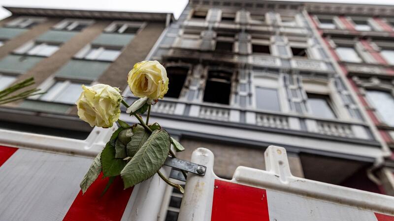 Verdächtiger für vierfachen Mord in Solingen ermittelt Eine weiße Rose an einer Absperrbake vor dem Brandort in Solingen am 27. März.