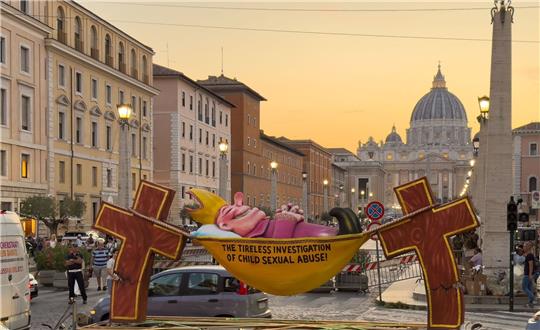 Einer Figur des Künstlers Jacques Tilly, die ironisch die Kirche für ihre Missbrauchsermittlungen kritisiert, steht in Rom in Sichtweite des Petersdoms.
