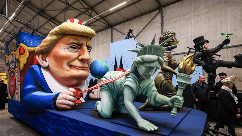 Trump, Musk und Putin im Kölner Rosenmontagszug Einer der Wagen im Kölner Rosenmontagszug zeigt US-Präsident Donald Trump, der die Freiheitsstatue und die Justitia am Laufband führt.
