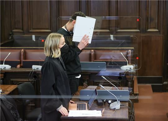 Einer von zwei wegen versuchten Totschlags angeklagten Männern wartet mit seiner Anwältin Nadine Werner in einem Gerichtssaal des Strafjustizgebäudes in Hamburg auf den Prozessbeginn. Foto: Ulrich Perrey/dpa