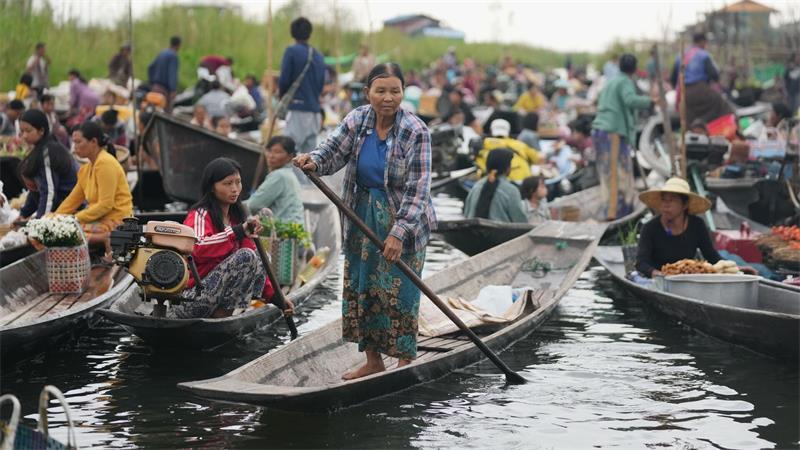 Einheimische rudern auf dem Inle-See in Myanmar mit ihren Booten auf einem dortigen schwimmenden Markt.