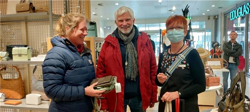 Einkaufsbummel einmal ohne Mundschutz: Frank und Petra Neugebauer in der Taschenabteilung mit Stackmann-Verkäuferin Siegrid Wichern.