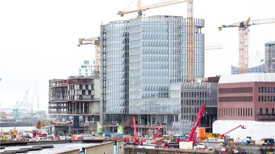 Einsatzfahrzeuge und Kräne stehen in der Hafencity auf einer Baustelle.