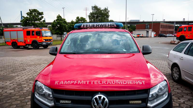 Einsatzfahrzeuge von Feuerwehr und Kampfmittelräumdienst stehen im Stadtteil Waltershof vor der Köhlbrandbrücke. 