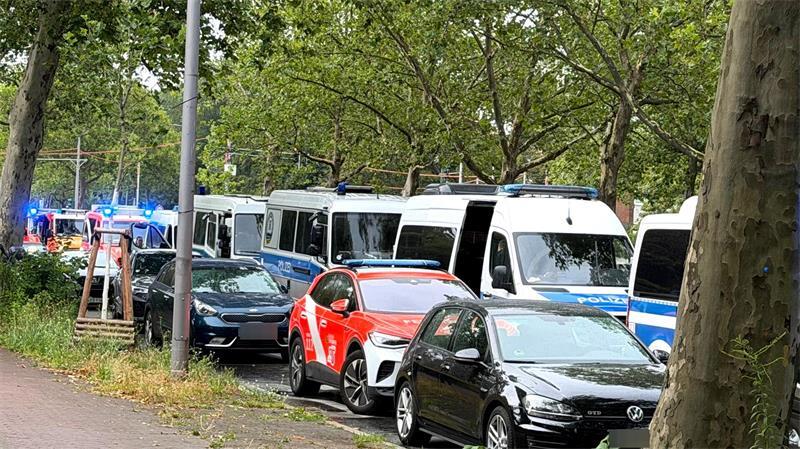 Einsatzfahrzeuge von Polizei und Feuerwehr stehen am Straßenrand nahe einer Kleingartenkolonie in Spandau.