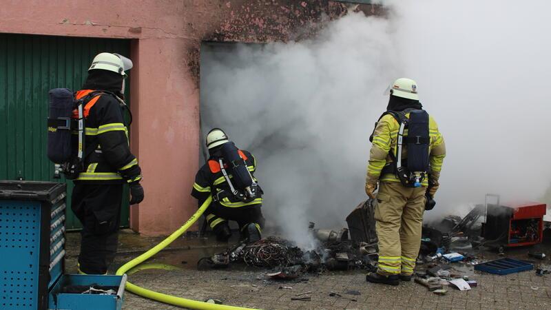 Einsatzkräfte Löschen das Feuer in der Garage.