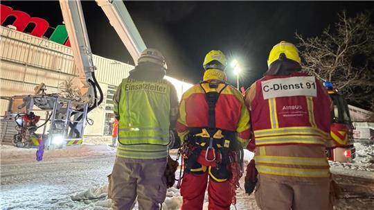 Einsatzkräfte beraten sich vor einem Baumarkt.