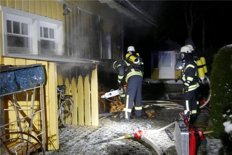 Einsatzkräfte brachten den brennenden Holzhaufen in sicherem Abstand zum Gebäude und löschten ihn ab.
