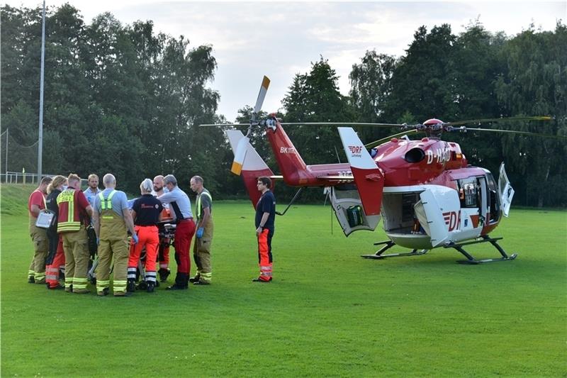 Einsatzkräfte bringen den schwer verletzten Ottenbecker auf dem VfL-Sportplatz zum Rettungshubschrauber Christoph Weser. Foto: Beneke