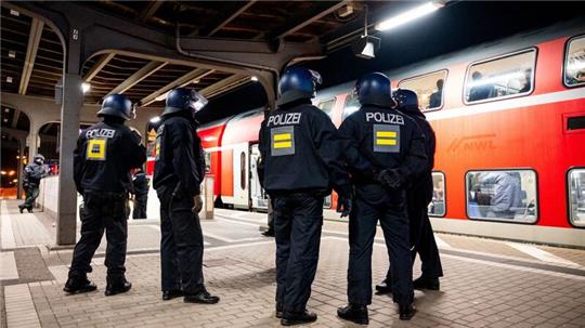 Einsatzkräfte der Bundespolizei stehen am Bahnhof Bergedorf an einem Regionalzug.