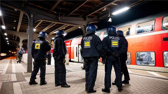 Einsatzkräfte der Bundespolizei stehen am Bahnhof Bergedorf an einem Regionalzug.