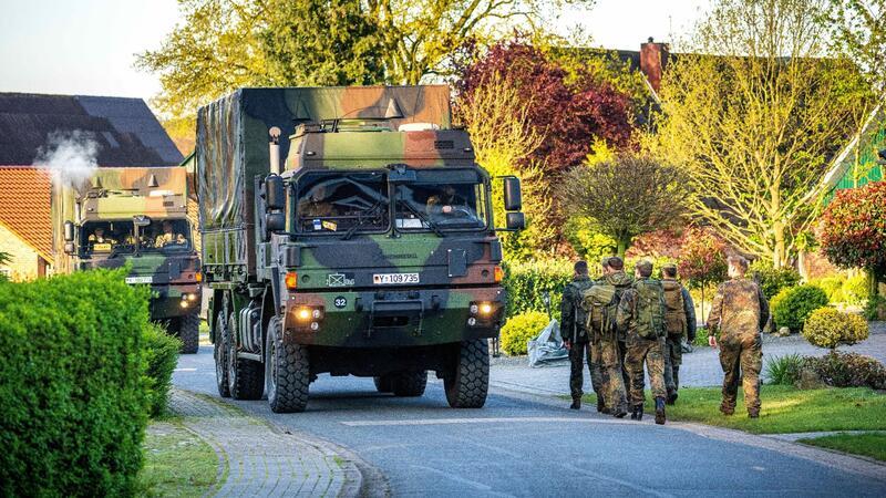 Einsatzkräfte der Bundeswehr laufen durch den Wohnort des vermissten Jungen.