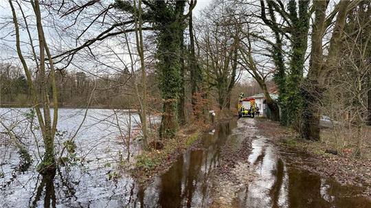 Einsatzkräfte der Feuerwehr Oldendorf auf der überschwemmten Zufahrt zu den Sunder Gutshäusern.