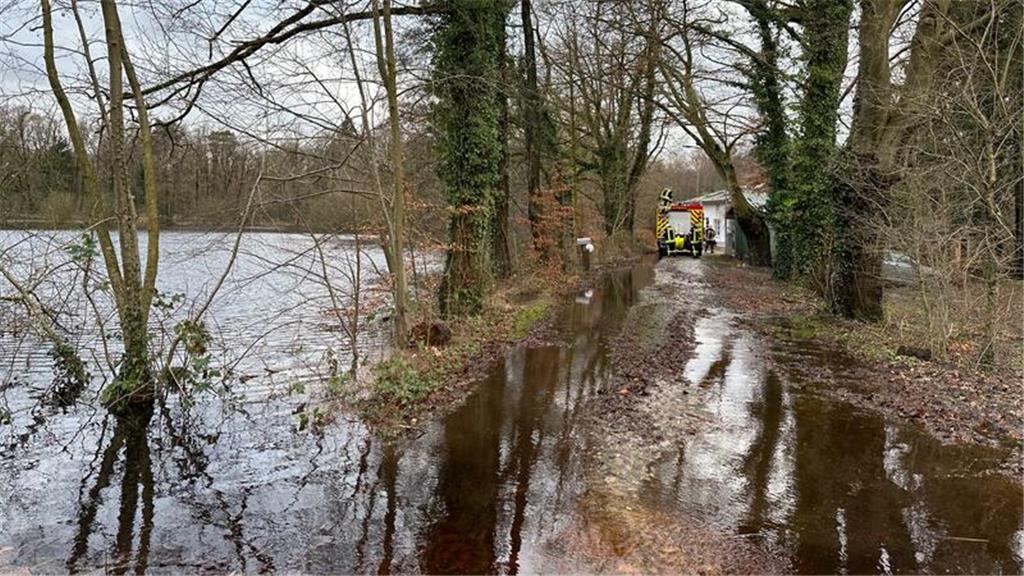 Einsatzkräfte der Feuerwehr Oldendorf auf der überschwemmten Zufahrt zu den Sund...