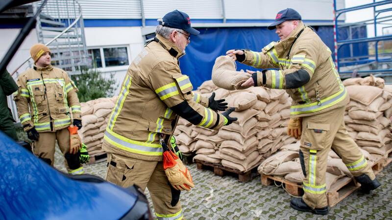 Einsatzkräfte der Feuerwehr geben auf einem Parkplatz zahlreiche Sandsäcke an die Anwohner im Bereich der Hunte am Achterdiek aus. Die Hochwasserlage bleibt in vielen Regionen Niedersachsens angespannt.