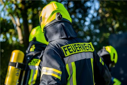 Einsatzkräfte der Feuerwehr in Schutzkleidung.
