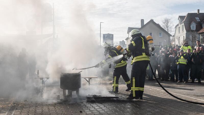 Einsatzkräfte der Feuerwehr löschen ein Feuer vor der Stadthalle.