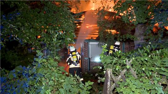 Einsatzkräfte der Feuerwehr löschen ein historisches Fachwerkhaus mit Reetdach. Das leerstehende Gebäude ist aus noch unbekannter Ursache vollständig abgebrannt. Foto: Daniel Bockwoldt/dpa