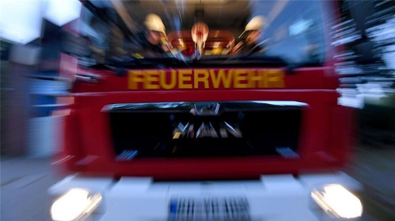 Einsatzkräfte der Feuerwehr sitzen in ihrem Fahrzeug. (zu dpa: «Feuer in Wohnhaus – drei Menschen verletzt»)