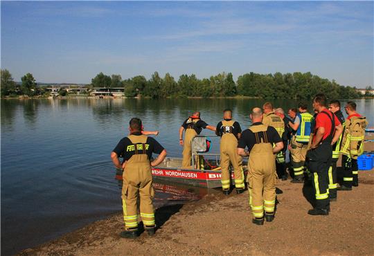 Einsatzkräfte der Feuerwehr stehen am Sundhäuser See. Im Sundhäuser See nahe Nordhausen sind am Samstag zwei Menschen beim Tauchen ums Leben gekommen. Foto: picture alliance/dpa/dpa-Zentralbild | Silvio Dietzel